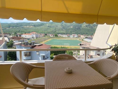 a table and chairs on a balcony with a tennis court at Sava's House in Berat
