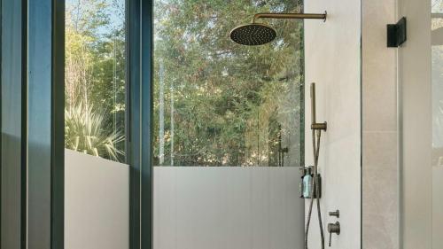 a shower door in a bathroom with a window at Luxury Mirror Home In Byron Bay in Byron Bay