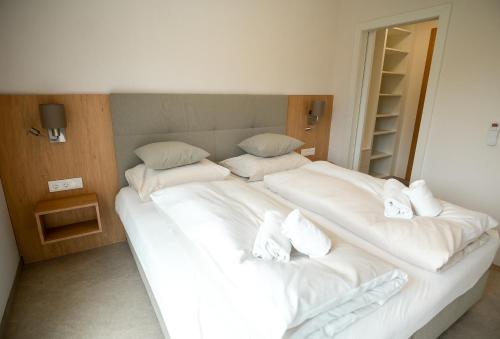 a bedroom with two beds with white sheets and pillows at OpenSky Wörthersee Lodge in Pörtschach am Wörthersee