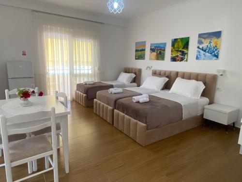 a bedroom with two beds and a table and a dining room at Sava's House in Berat