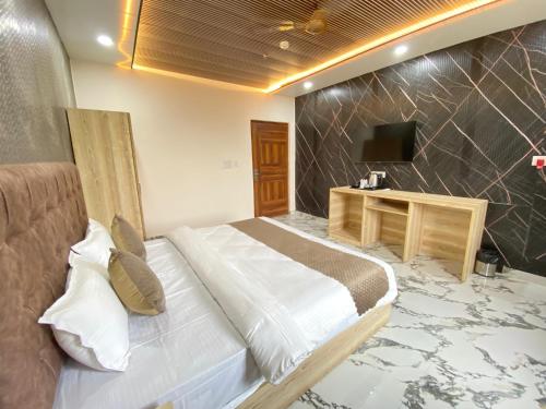 a bedroom with a bed and a television in it at Hotel Ganga Pearl in Rishīkesh