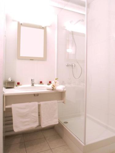 une salle de bain blanche avec un lavabo et une douche dans l'établissement Hotel Résidence Anglet Biarritz-Parme, à Anglet
