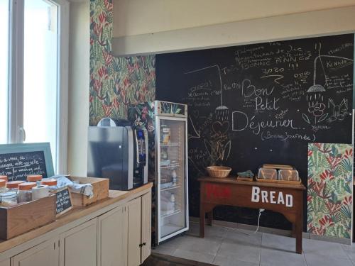 a kitchen with a chalkboard wall with a refrigerator at Pause ton sac # Relais Saint Jacques #Venez dormir chez nous in Condom