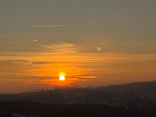 a sunset with the sun in the sky at Panoramic View Harz in Altenau