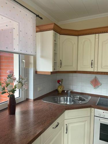 a kitchen with white cabinets and a sink at Neue Ferienwohnung mit Terrasse in Guteborn
