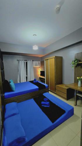 a room with two blue beds and a table at Studio With Citylights and SEAview near MALL inside IT PARK in Sampong