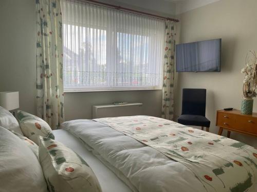 a bedroom with a bed and a window and a chair at Neue Ferienwohnung mit Terrasse in Guteborn