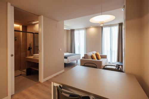a living room with a table and a living room with a couch at BN SUITES San Francisco in Alicante