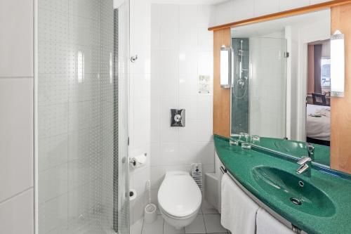 a bathroom with a sink, toilet and shower at Ibis Praha Old Town in Prague