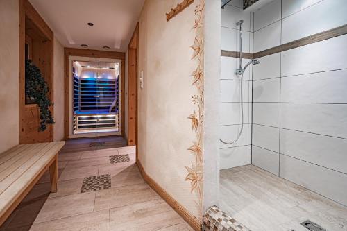 a bathroom with a shower and a bench at Hotel Rösslwirt in Kirchberg in Tirol