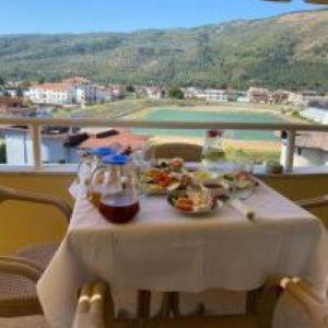 a table with food on top of a balcony at Sava's House in Berat