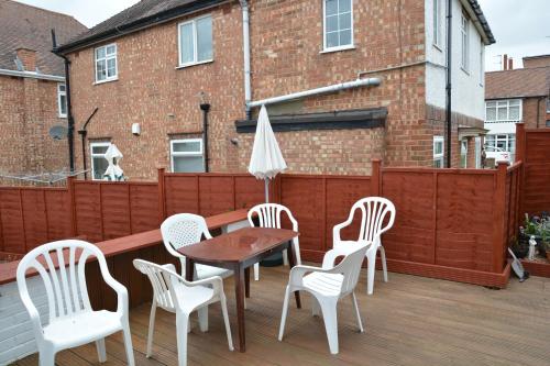 a patio with chairs and a table and an umbrella at Sherwood Lodge in Skegness