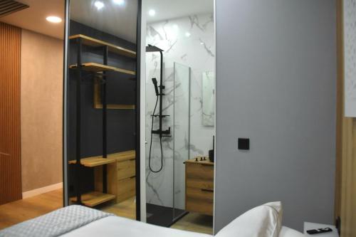 a bedroom with a shower with a glass door at Nómada Orzán bajo in A Coruña