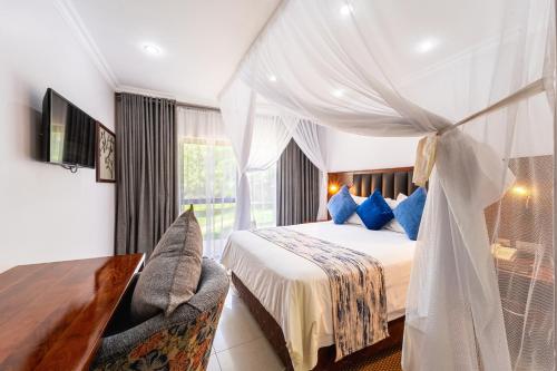 a bedroom with a bed with blue pillows at Azambezi River Lodge in Victoria Falls