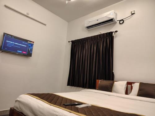 a hotel room with two beds and a tv at THE VILLA Pondicherry in Puducherry