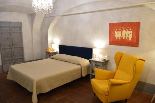 a bedroom with a bed and a yellow chair at Il Viaggiatore 2 in Anagni
