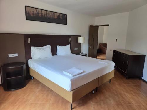 a bedroom with a large bed with a white bedspread at Vila Silvia in Eforie Sud