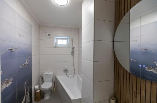 a bathroom with a tub and a toilet and a sink at Park Apartman in Sarród