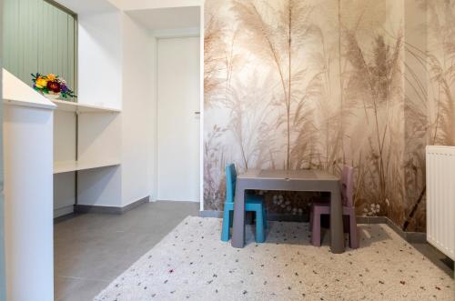 a table and chairs in a room with a wall at Park Apartman in Sarród