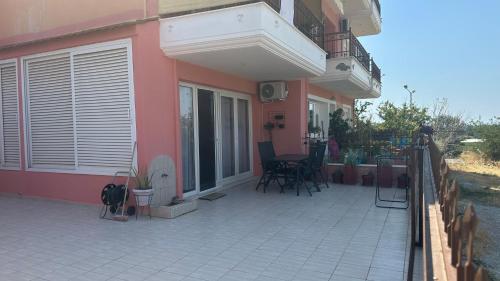 a pink house with a patio with chairs and tables at Sky studio in Nea Kalikratia