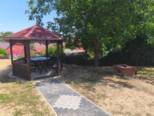 a gazebo with a bench in a yard at Gyöngyvirág Apartmanház in Zalakaros