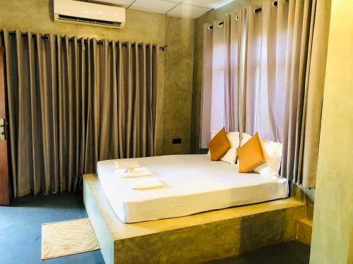 a hotel room with a bed with a window at Wilpattu Nature Resort in Murandanveli