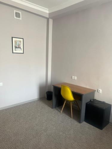 an office with a desk and a yellow chair at Osh Art Hotel in Osh