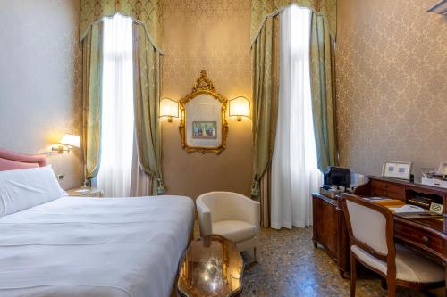 a hotel room with a bed and a desk and a desk at Hotel Colombina in Venice
