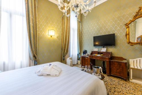 a hotel room with a bed and a television at Hotel Colombina in Venice