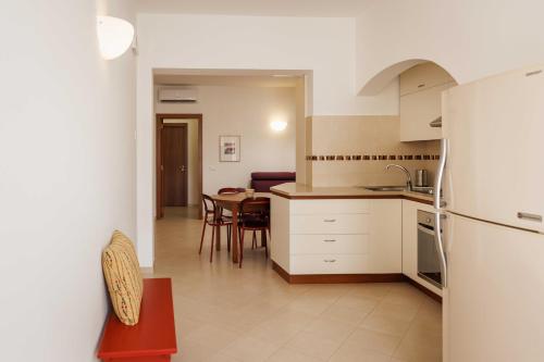 a kitchen and dining room with a table and a refrigerator at Suite Sabean in Monopoli