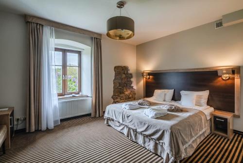 a bedroom with a large bed and a window at Dwór Kombornia - Folwark in Kombornia