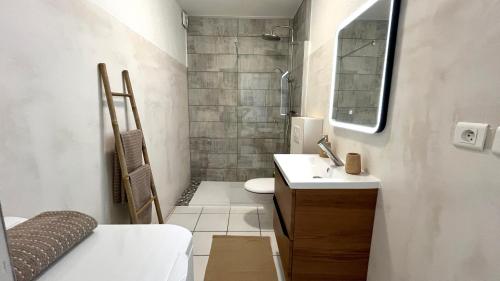 a small bathroom with a sink and a shower at Gîte Le 25 in Ingersheim