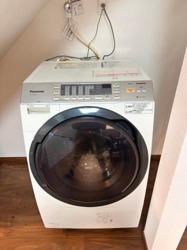 a white washing machine is sitting on a floor at Kyoto Station Lanshin in Kyoto