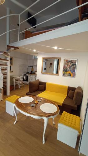 a living room with a yellow couch and a table at Pécs Inn in Pécs