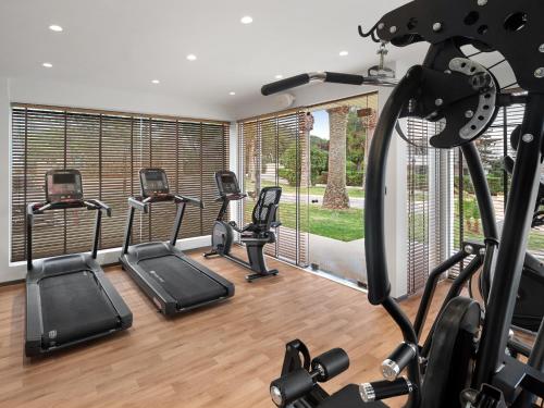 a gym with a row of treadmills and cardio equipment at Creta Royal - Adults Only in Skaleta