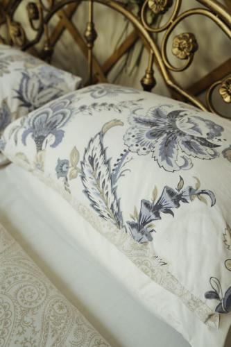 a bed with a blue and white pillow on it at Gingerbread Cottage Yurts in East Dereham