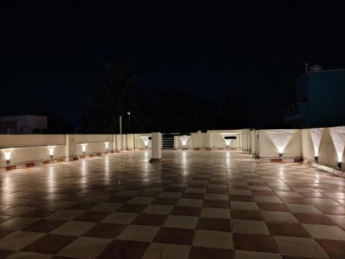 a checkerboard tile floor with lights on it at night at THE VILLA Pondicherry in Puducherry