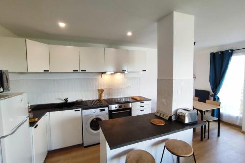 une cuisine avec des armoires blanches et un comptoir dans l'établissement Night in the Heart of Torcy, à Torcy