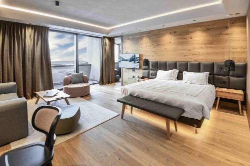 a bedroom with a large bed and a living room at Swissôtel Damian Jasna in Demanovska Dolina