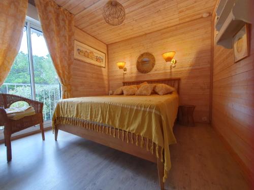 sypialnia z łóżkiem w pokoju z drewnianymi ścianami w obiekcie Villa "Le Mirage" w mieście Cap-Ferret