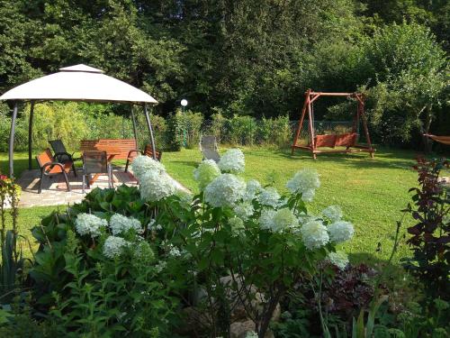 a garden with a table and chairs and an umbrella at Domek Żabie Oczko in Jarnołtówek