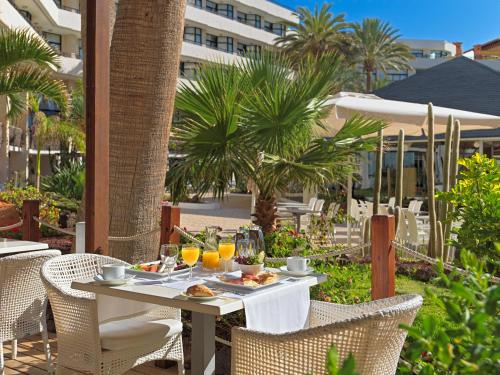 un tavolo con cibo e bevande su un patio di H10 Conquistador a Playa de las Americas