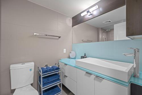a bathroom with a sink and a toilet and a mirror at Classy 1-Bedroom & Den Condo in Heart of Downtown in Toronto