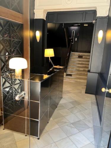 a lobby with a desk with a lamp and a staircase at Hostal Iznájar Barcelona in Barcelona
