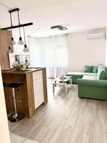 a living room with a green couch and a table at Bella LUX in Modriča