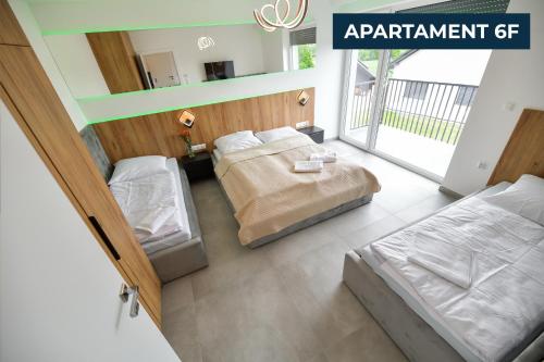 a bedroom with two beds and a sign that reads apartment at Słoneczne Wzgórze Zator in Zator