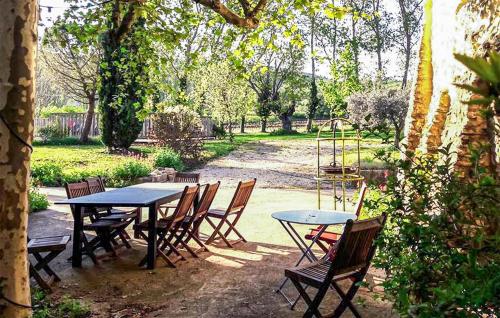 Un grupo de mesas y sillas en un jardín. en Maison Avec Piscine Privée, en Malaucène