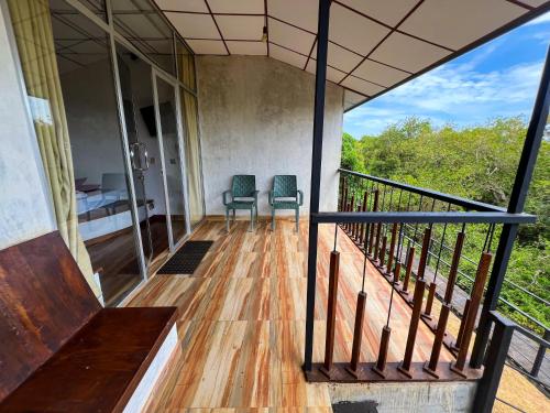 a room with two chairs and a bed on a balcony at Wilpattu Nature Resort in Murandanveli