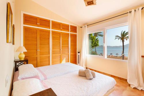 Un dormitorio con dos camas y una gran ventana. en La Gola, en La Manga del Mar Menor