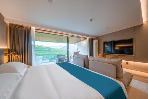 a large bed in a room with a large window at Longji Vista Retreat--Panoramic View of Terrace, Sunrise ,Heated Pool & Affordable Luxury in Longsheng